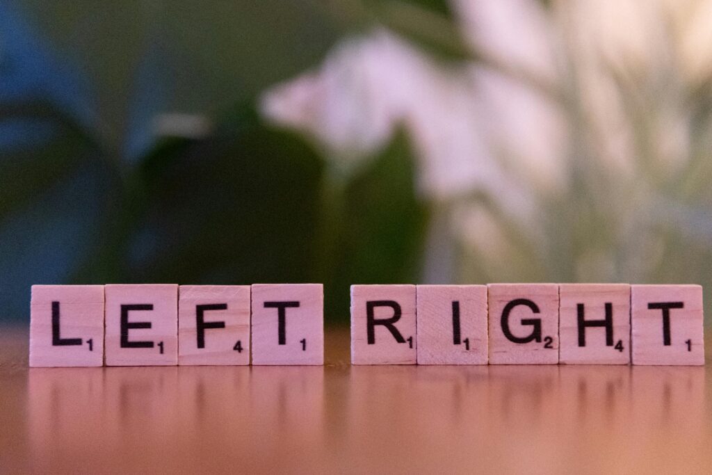Scrabble tiles spelling 'left' and 'right' on a wooden surface with blurred background.