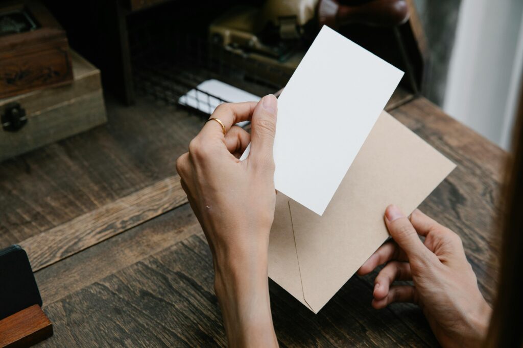 Hands holding an envelope and blank card, conveying simplicity and elegance.